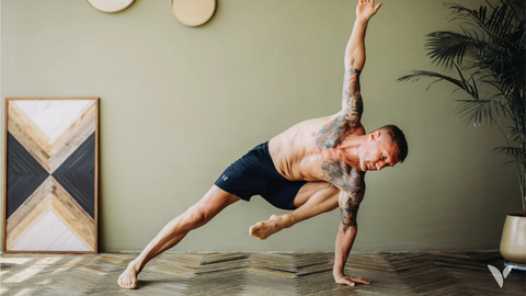 Athlète tatoué en posture de yoga, illustrant la force et la souplesse d'un régime végétal riche en protéines